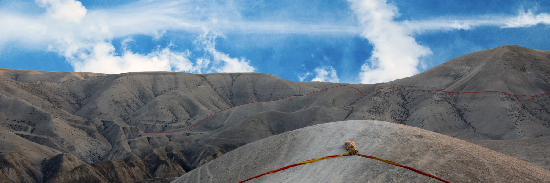 Fabric in the foreground of a rocky landscape under a blue sky.